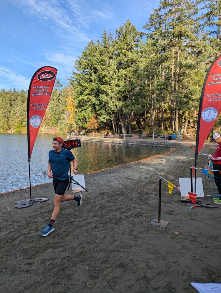 Jacob Haas crossing finish line at trail race on sandy beach Vancouver Island BC